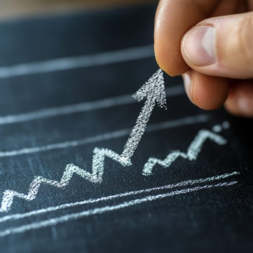 Hand drawing an upward arrow on a chalkboard, symbolizing growth and success. Hand drawing an upward arrow on a chalkboard, symbolizing growth and success.